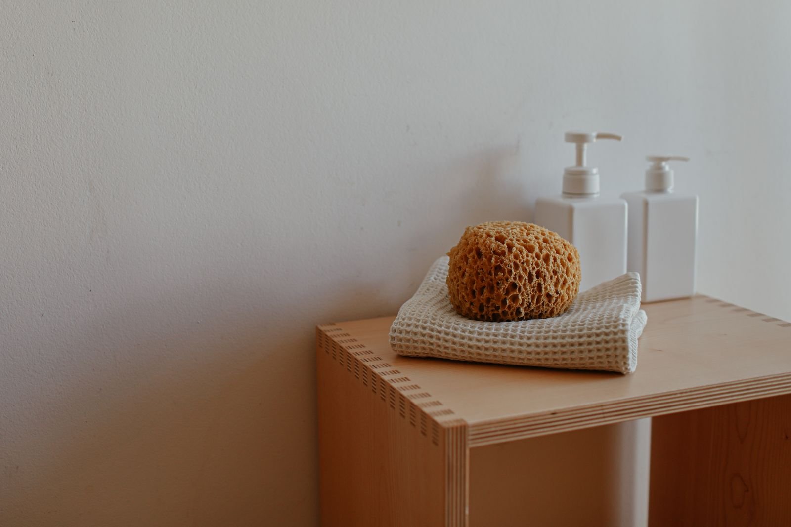 Serviette propre pliée et éponge sur une tablette de salle de bain